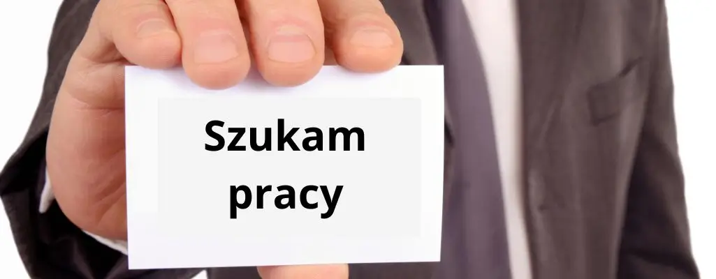 Zdjęcie w artykule - jak szukać pracy. Obrazek przedstawia mężczyznę w ciemnym garniturze, który wyciąga rękę z wizytówką, na której napisane jest po polsku "Szukam pracy". Mężczyzna jest widoczny tylko częściowo, skupiamy się głównie na jego dłoni trzymającej wizytówkę. Ujęcie jest tak skonstruowane, że widzimy tylko rękę i fragment garnituru, bez pokazywania twarzy. To może symbolizować anonimowość i uniwersalność doświadczenia poszukiwania pracy. Scena jest prosta, ale mocno oddziałuje na emocje, sugerując determinację oraz bezpośrednie i aktywne podejście do poszukiwania zatrudnienia.